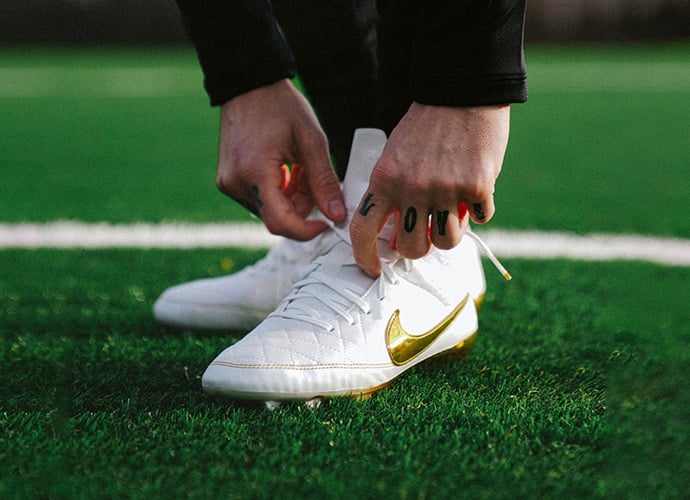Veteran player wearing comfortable football boots on the pitch