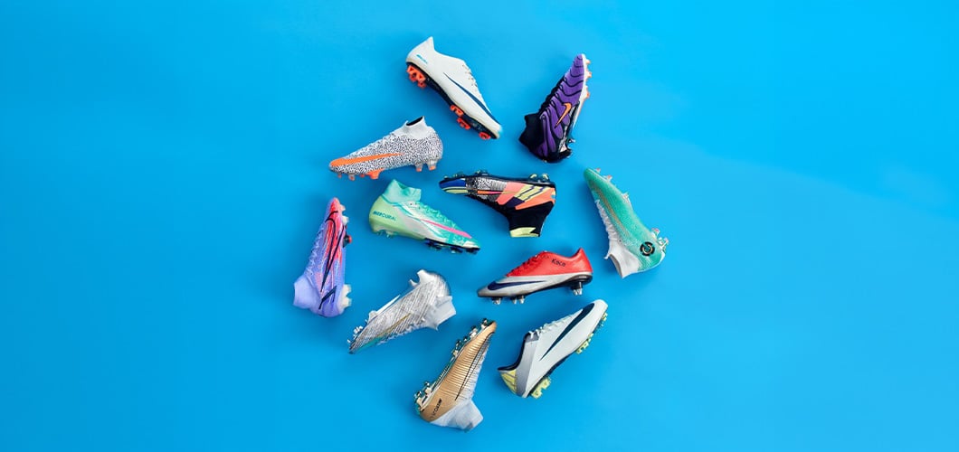 Collection of Nike Mercurial Superfly football boots in various colorways including white, purple, pink, mint green and orange on blue backdrop