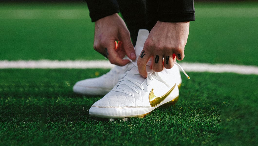 Veteran player wearing comfortable football boots on the pitch