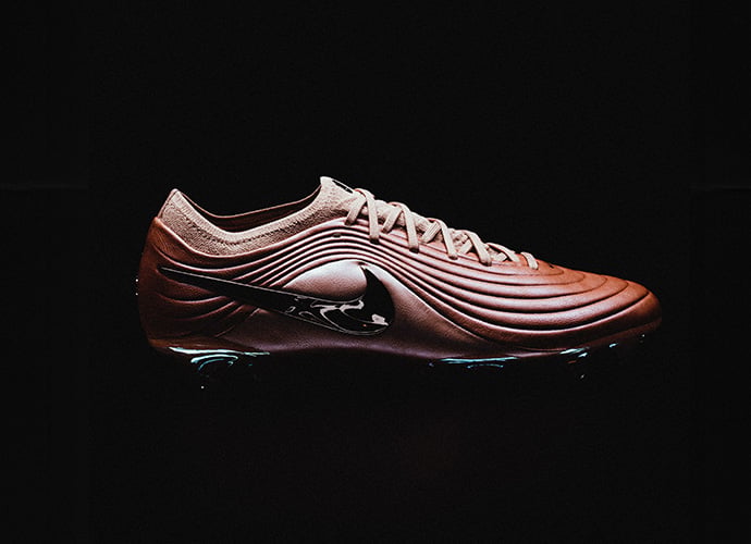 Nike Tiempo Maestro football boot in copper/bronze colorway featuring dynamic ribbed upper design and modern aesthetic against black background