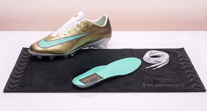 Football boot drying with the insole and laces taken out and laid on a towel