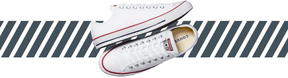 Converse Chuck Taylor All Star Low Sneaker blanc vu de dessus, chaussure gauche posée sur le côté, semelle parallèle à la chaussure droite debout, permettant de voir la semelle intérieure de l'intérieur.