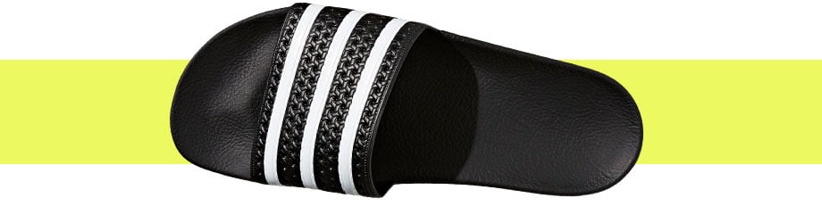 adidas Originals Adilette Schwarz Weiß, Draufsicht mit gutem Blick auf den Riemen und das vorgeformte Fußbett darunter, das durch Licht und Schattenwurf hervorgehoben wird