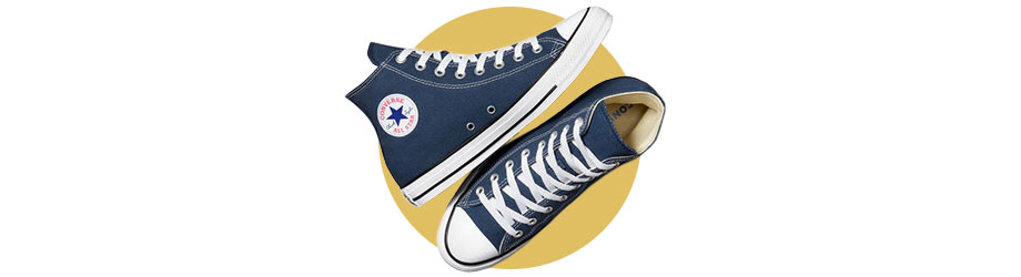 Converse All Star Sneaker mit High Cut in komponierter Pose mit linkem Schuh liegend und rechtem Schuh stehend, von oben mit Draufblick fotografiert