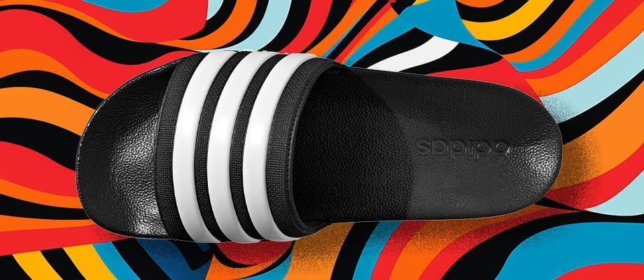 adidas Cloadfoam Adilette Regular in Schwarz in Aufsicht mit Blick auf den den Riemen mit eingeprägten adidas 3-Stripes vor einem bunten Wellenlinienhintergrund