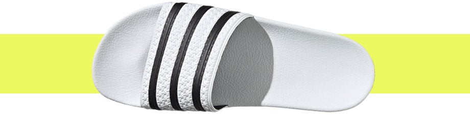 adidas Originals Adilette Weiß, Draufsicht mit gutem Blick auf den Riemen und das vorgeformte Fußbett darunter, das durch Licht und Schattenwurf hervorgehoben wird