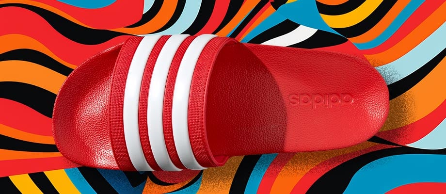 adidas Cloadfoam Adilette Regular in Rot in Aufsicht mit Blick auf den den Riemen mit eingeprägten adidas 3-Stripes vor einem bunten Wellenlinienhintergrund