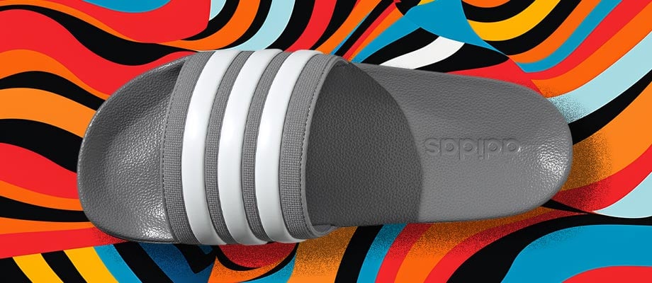 adidas Cloadfoam Adilette Regular in grigio in vista dall'alto con vista sul cinturino con le tre strisce adidas incise su uno sfondo di linee ondulate colorate