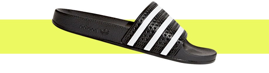 adidas Originals Adilette Schwarz Weiß, seitlicher Blick auf die rechte Badelatsche Außenseite mit adidas Trefoil-Logo seitlich auf dem Sohlenrahmen