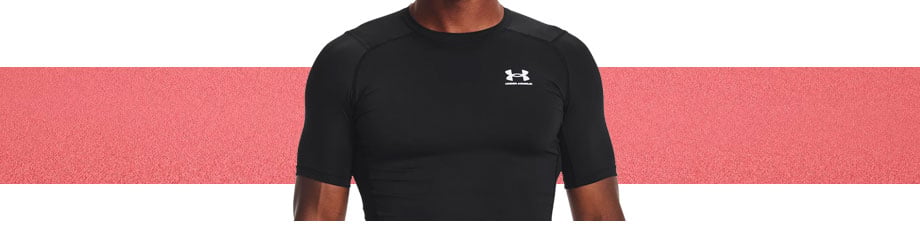 Under Armour HG Compression T-Shirt Schwarz, Detailansicht Schulter- und Brustpartie vorne mit UA-Logo in Weiß links auf der Brust, Raglanschnitt mit baselayertypisch außenliegenden Nähten