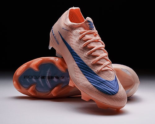 Paire de chaussures Vapor 16 couleur saumon, l'une montrant la semelle, l'autre pos&eacute;e dessus offrant une bonne vue du c&ocirc;t&eacute; lat&eacute;ral et du la&ccedil;age