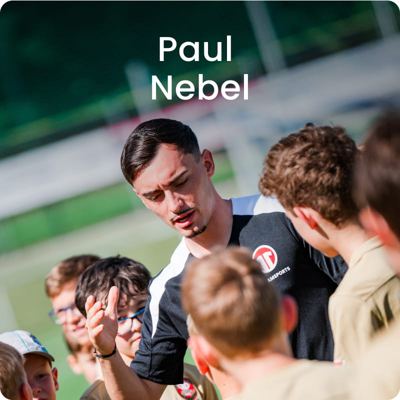 German international Paul Nebel posing with young boys in black football kit - 11teamsports Football Academy ambassador
