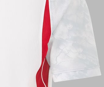 Gros plan sur le tricot respirant avec graphismes mythologiques sur les manches et inserts en mesh sur les c&ocirc;t&eacute;s