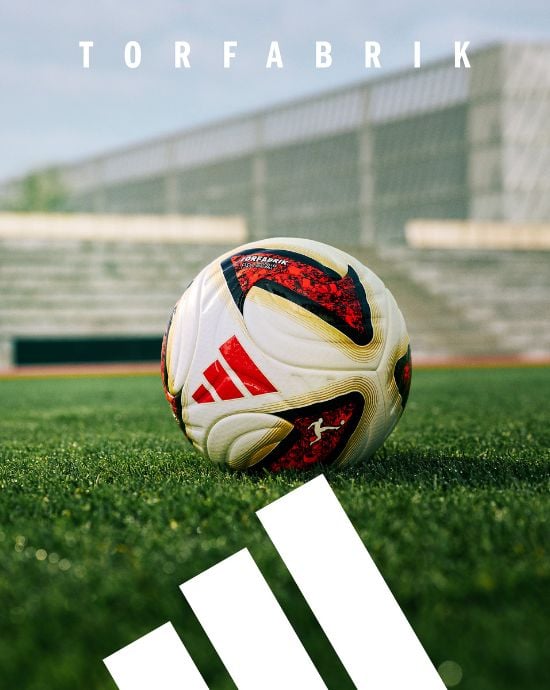 adidas Torfabrik football on stadium pitch with white adidas stripes and Torfabrik text overlay - official Bundesliga match ball