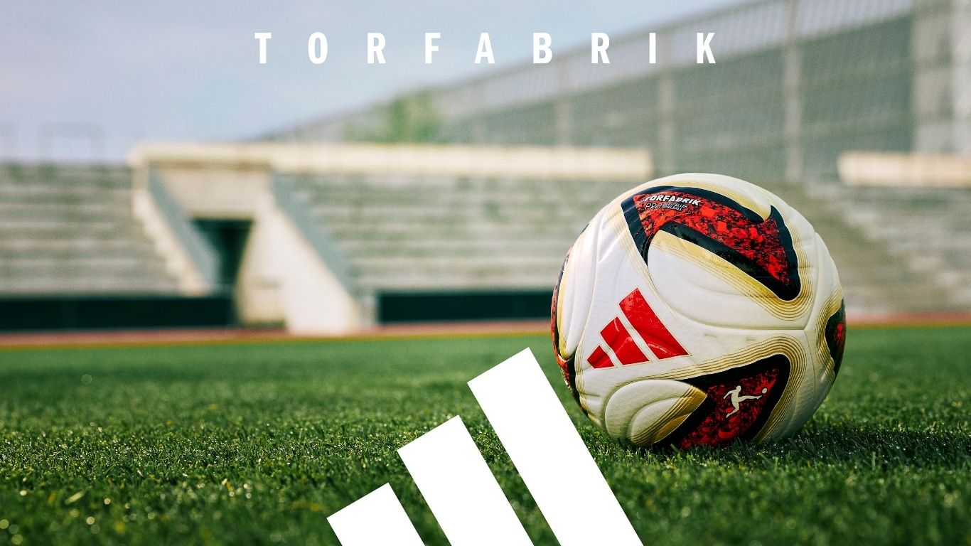 adidas Torfabrik football on stadium pitch - official Bundesliga match ball with red and white design