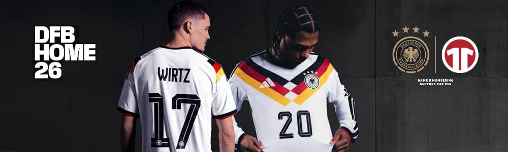 Wirtz und Gnabry im WM-Heimtrikot der deutschen Nationalmannschaft, Wirtz mit R&uuml;cken zu uns seine Nummer 17 zeigend, Gnabry schaut an seinem Trikot hinunter auf das Best-of-Design aus 1990 mit dem Rautenthema und dem V-f&ouml;rmigen Bruststreifen aus dem Weltmeistertrikot 2014, das die Vorlage f&uuml;r die Gestaltung der DFB Home Collection gedient hat