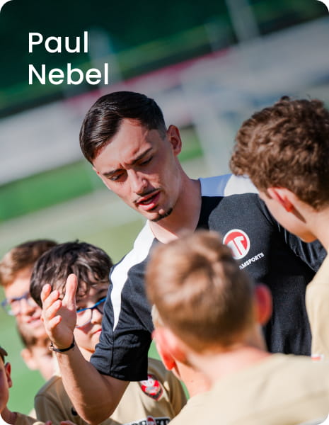 German international Paul Nebel posing with young boys in black football kit - 11teamsports Football Academy ambassador