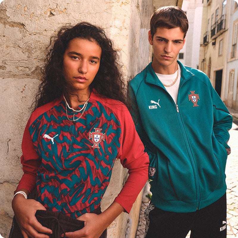Two models wearing red patterned Portugal pre-match shirt and teal Puma FPF track jacket - Shop Puma Lifestyle at 11teamsports