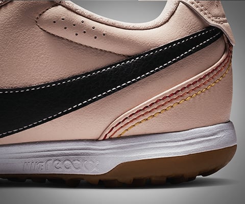 Gros plan de la partie arri&egrave;re lat&eacute;rale de la chaussure avec les trois lignes de couture Signature 10R en jaune, orange et rouge fonc&eacute; comme seul indicateur subtil visible et r&eacute;f&eacute;rence &agrave; 10R et vue directe sur la semelle interm&eacute;diaire amortissante NIKE react