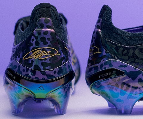 Gros plan sur le talon des crampons signature avec motif jaguar violet scintillant et noir et signature de Kak&aacute; en dor&eacute;