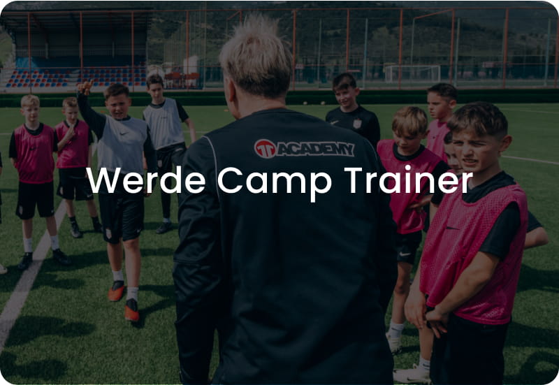 Football coach in black 11teamsports Academy jacket leading group of young players in pink kits on stadium pitch - Become a Camp Coach at 11teamsports Academy