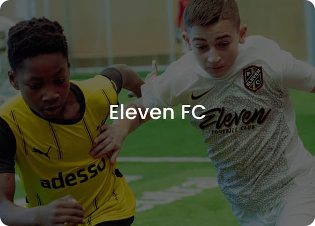Two boys competing for the ball in yellow and white football kits - Eleven FC youth football club at 11teamsports Academy