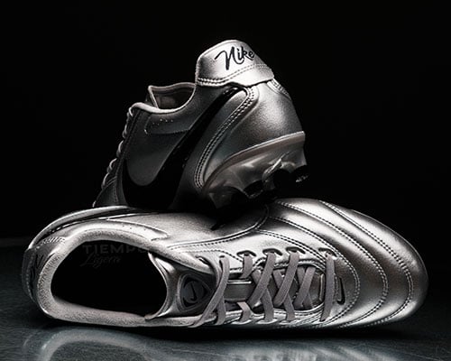 Pair of silver special edition Ligeras arranged: one shoe lying on side shows upper, lacing, tongue and collar rim. Other shoe behind is ramped on top and shows heel.