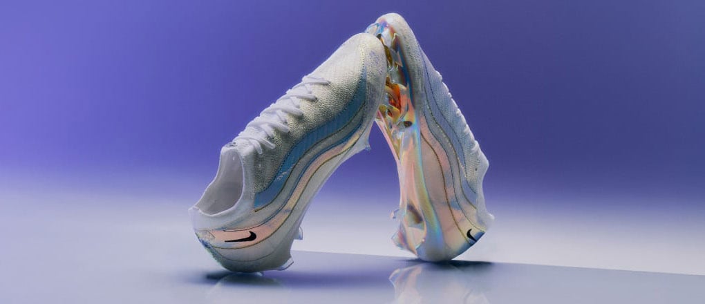 Ein Paar Nike Vapor Elite x Air Max 95 Special Edition Fußballschuhe arrangiert zu einer Pyramide vor lilablauen Gradient Hintergrund
