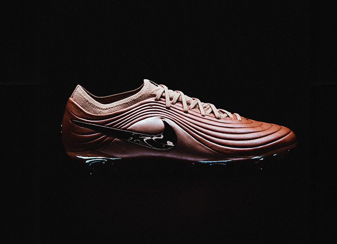 Nike Tiempo Maestro football boot in copper/bronze colorway featuring dynamic ribbed upper design and modern aesthetic against black background