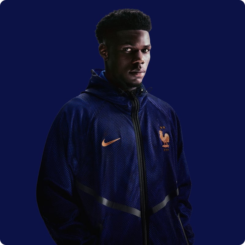 Model wearing navy blue Nike France FFF lifestyle jacket with orange swoosh - Shop Nike Lifestyle at 11teamsports