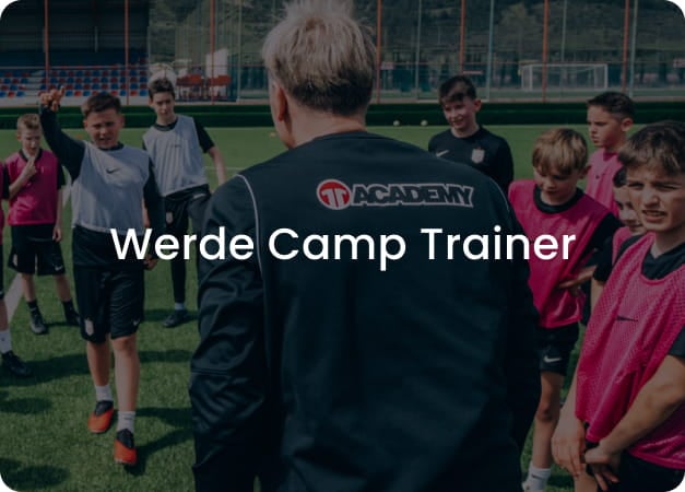Football coach in black 11teamsports Academy jacket leading group of young players in pink kits on stadium pitch - Become a Camp Coach at 11teamsports Academy