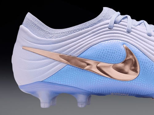 Gros plan sur le swoosh brillant plaqu&eacute; cuivre du mod&egrave;le Tiempo Maestro Elite