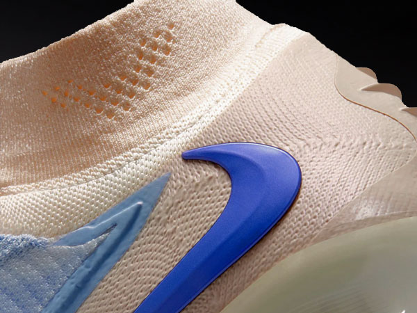 Gros plan sur la partie talon avec swoosh, contrefort de talon avec ailettes 3D et col montant avec mesh int&eacute;gr&eacute;