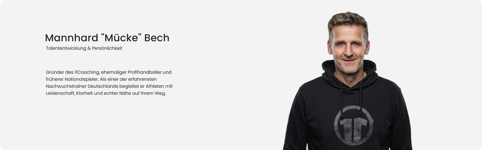 Mannhard Mücke Bech, founder of 11Coaching and former professional handball international, smiling in black 11Coaching hoodie - Talent development and personality expert at 11teamsports Football Academy