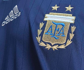 Embroidered adidas Performance logo and official AFA federation crest on chest of the dark blue away jersey