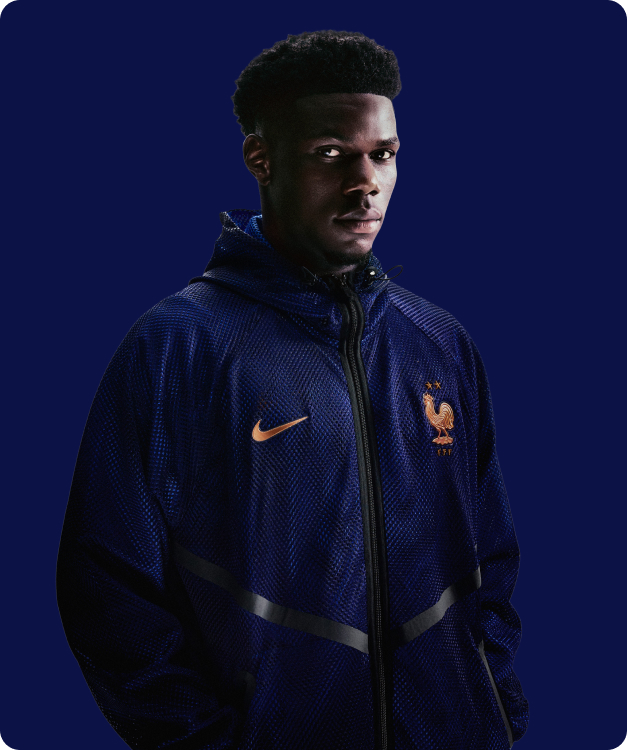 Model wearing navy blue Nike France FFF lifestyle jacket with orange swoosh - Shop Nike Lifestyle at 11teamsports