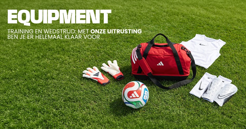 Football equipment on grass including red Adidas sports bag, goalkeeper gloves, football, training bibs and shin guards - Shop football equipment at 11teamsports