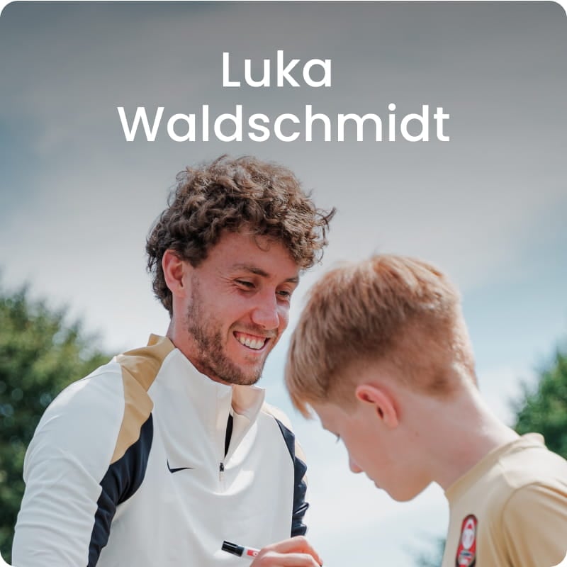 German international Luka Waldschmidt posing with young boy in white football kit - 11teamsports Football Academy ambassador